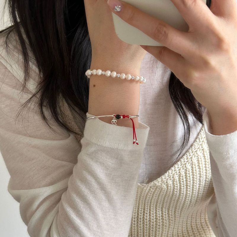 Pulsera de plata pura con diseño en capas de perlas de hilo rojo. Nueva primavera 2024. Versátil y moderna._voghion.com