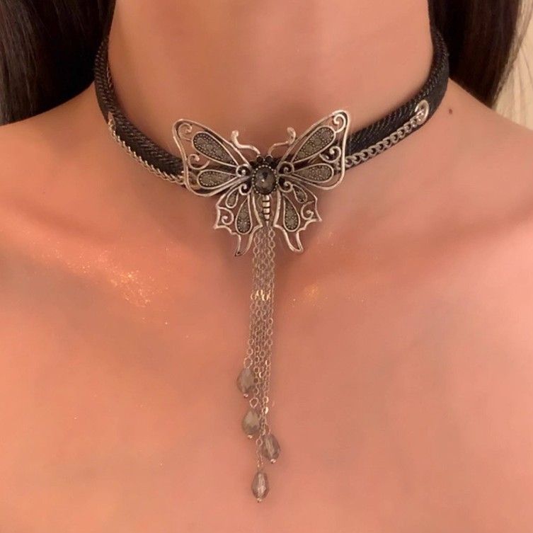 Collana girocollo corta con ciondolo a farfalla scura e frange, catena in pelle nera_voghion.com