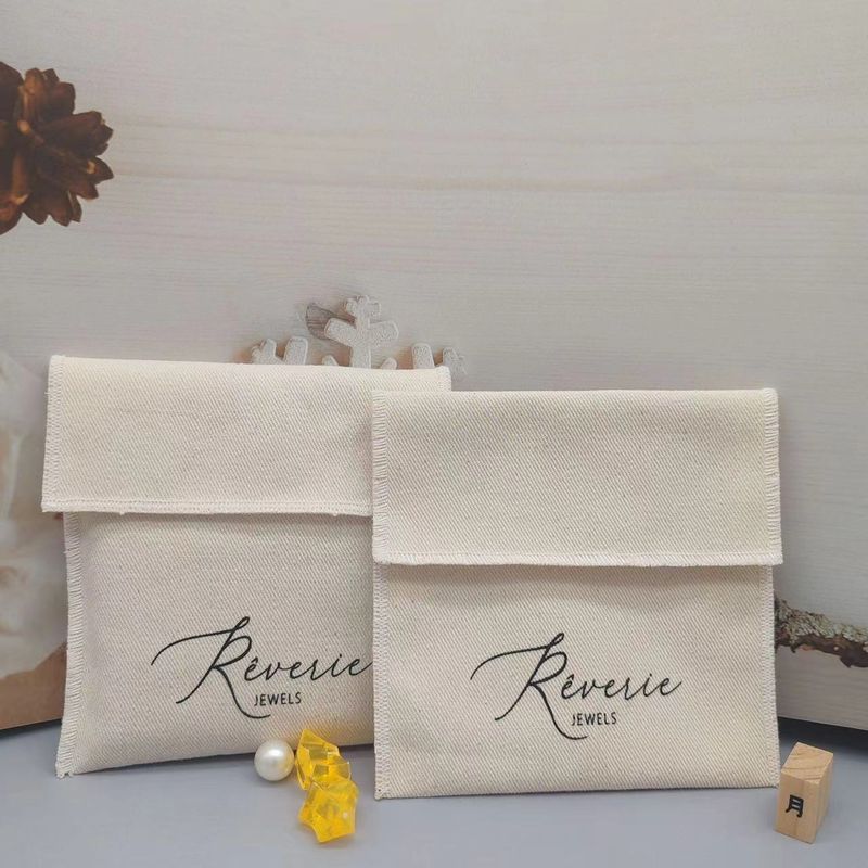 Pochette porte-cartes à rabat en toile sergée beige personnalisée, idéale pour ranger colliers, bracelets, bagues et boucles d'oreilles en argent._voghion.com