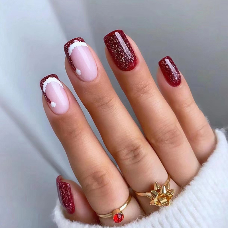 Mittellange, explosive, blutrote, süße Weihnachtsmütze, süßes Mädchen mit Nagelkunst, das fertiges Produkt trägt_voghion.com