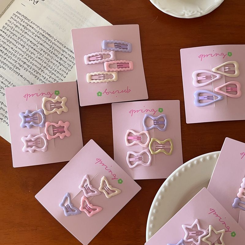 Nuovo set da 4 pezzi di accessori per capelli con frangia a forma di cuore, stella, fiocco e orsetto, in crema e rosa, 2025_voghion.com