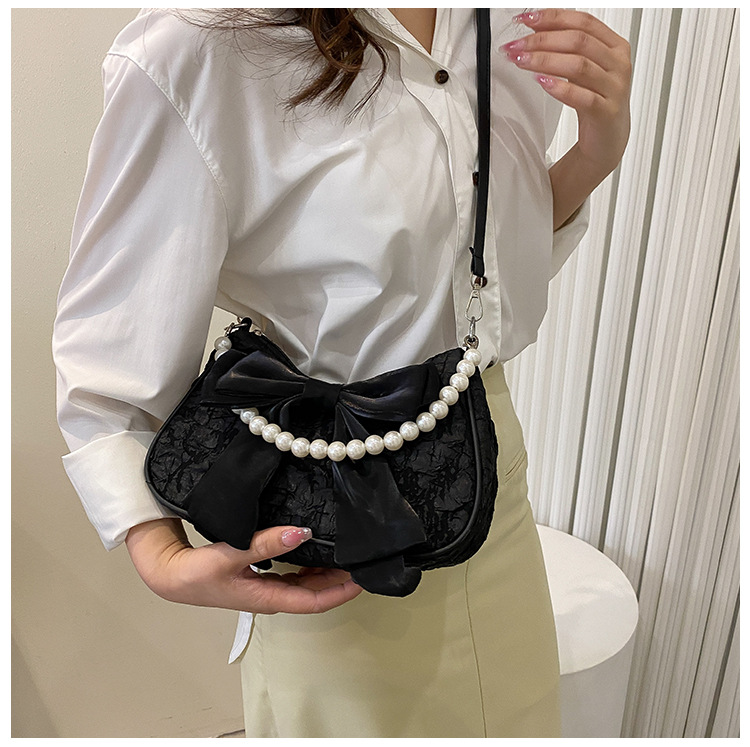 Il popolare fiocco di quest'anno per la primavera 2024 delle donne, la nuova borsa a tracolla singola sotto le ascelle con perle trendy e alla moda_voghion.com