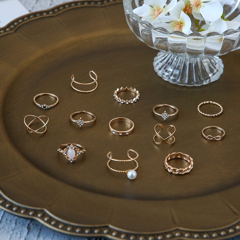 Conjunto de 13 anillos de joyería con corona de ópalo, cruz de diamantes y doble capa de perla._voghion.com