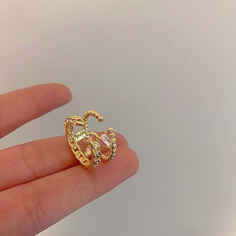 Goldfarbener, geflochtener Doppelring für Damen – Hohlzirkon-Detail, leichtes, luxuriöses Nischen-Zeigefinger-Design, verkupfert_voghion.com