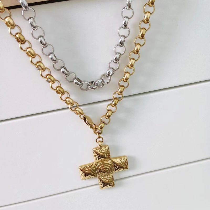 Collana con ciondolo a forma di croce in acciaio al titanio placcato oro e orecchini a catena con perline di acqua._voghion.com