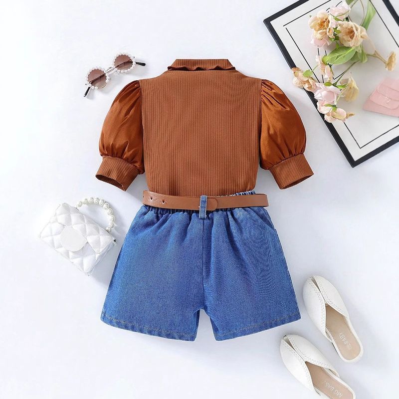 Conjunto mãe e filha com blusa de manga bufante com detalhes em patchwork, shorts jeans com lavagem pesada e cinto. Blusa com gola franzida e mangas bufantes para meninas, shorts jeans destroyed e cinto._voghion.com