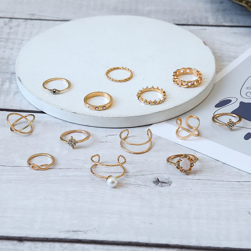 Conjunto de 13 anillos de joyería con corona de ópalo, cruz de diamantes y doble capa de perla._voghion.com