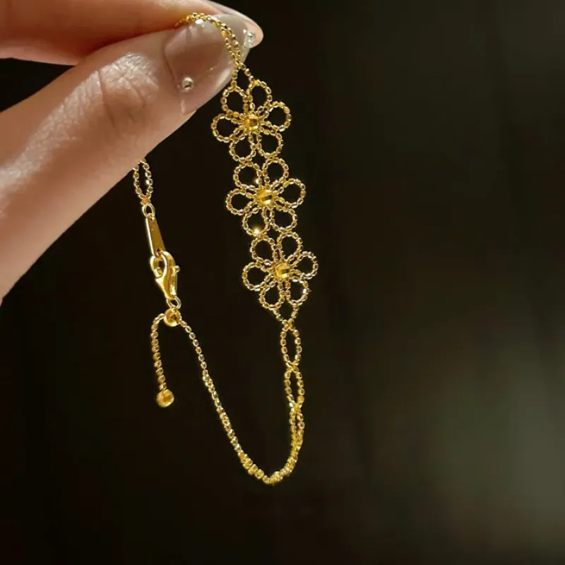 Braccialetto con fiori in pizzo color oro, motivo floreale in filigrana, chiusura regolabile con catena delicata, elegante e delicata atmosfera_voghion.com