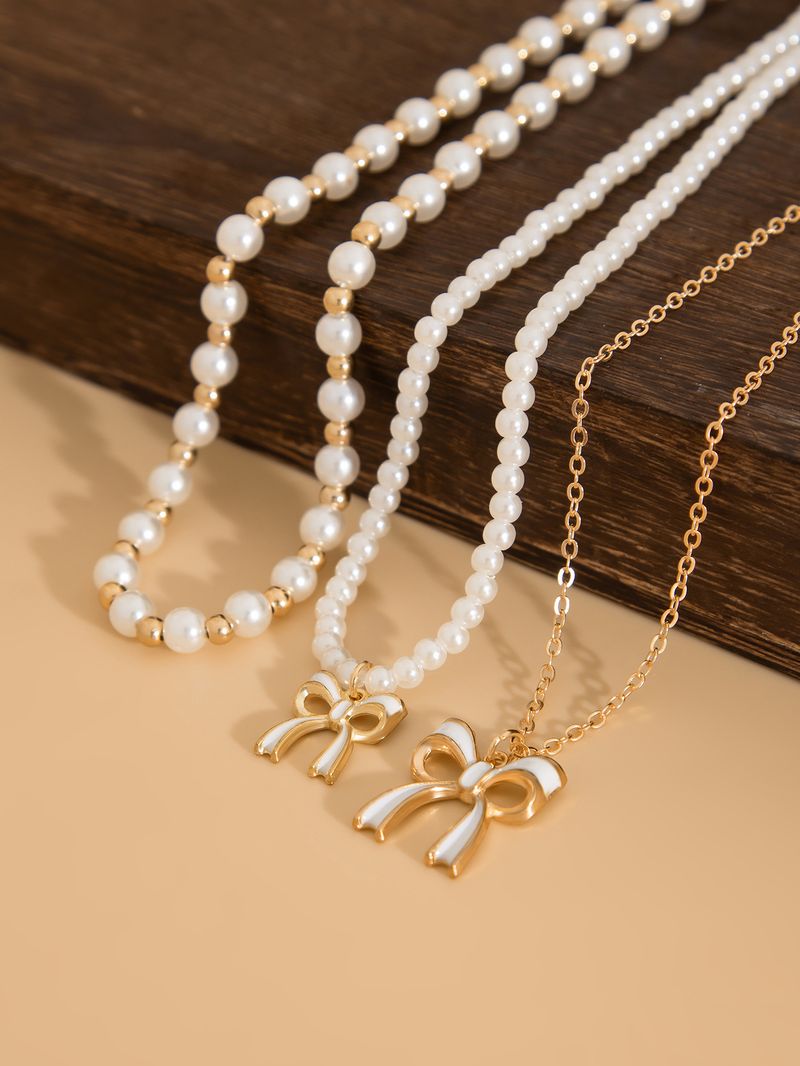 Set di collane a strati con perle e fiocco per donna, collana multifilo in perle finte color oro con ciondolo a fiocco in smalto, gioielli eleganti di ispirazione vintage_voghion.com
