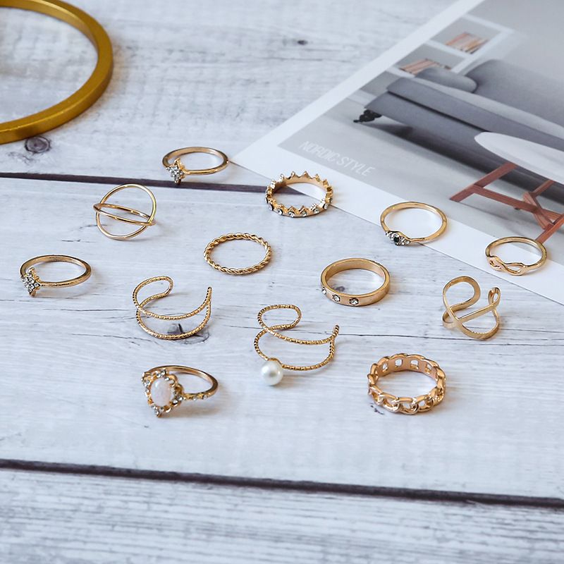 Conjunto de 13 anillos de joyería con corona de ópalo, cruz de diamantes y doble capa de perla._voghion.com